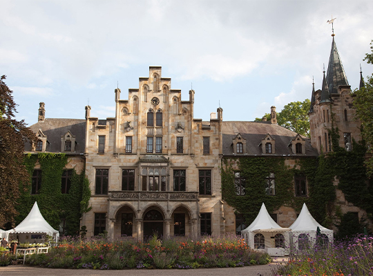 Schloss mit Pavillons und Blumenwiese