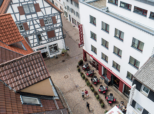 Blick vom Dach auf den Außenbereich des Restaurants in einer Gasse.