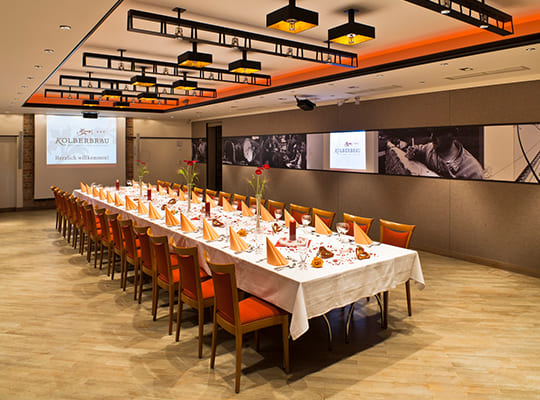 Lange Tischtafel im modern eingerichteten Speise- bzw. Konferenzsaal.