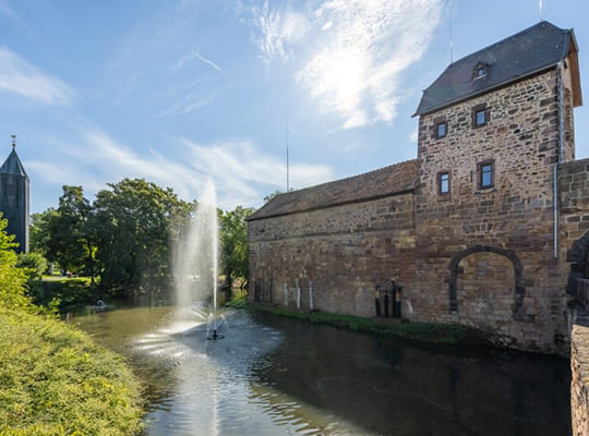 Bild der Wasserburg Bad Vilbel mit schönem blauen Himmel und ganz wenig Wolken.