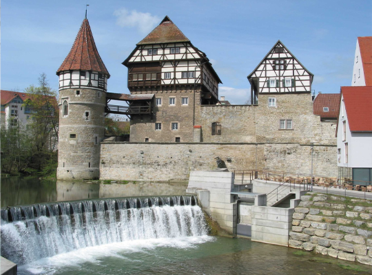 Bei Sonnenschein einen Rundgang am Wasser entlang genießen mit Aussicht auf die alten Fachwerkhäuser