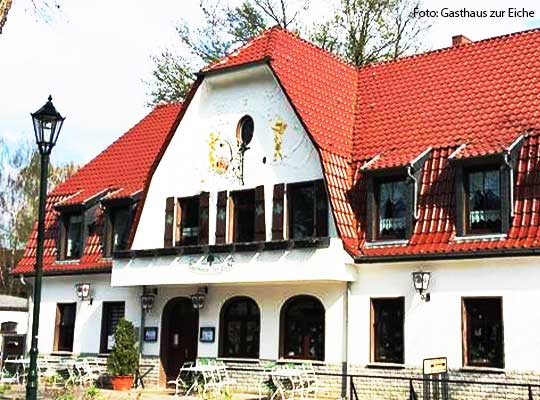 Schönes altes, aber gepflegtes Gasthaus mit weißer Fassade, Goldenen Engeln auf der Vorderseite und roten Dachziegeln.