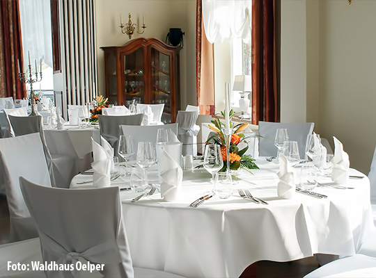 Stilvoll gedeckter runder Tisch in hellem Saal