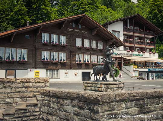 Großer Speisesaal mit heller Fensterfront inklusive Blick auf den Brienzersee.