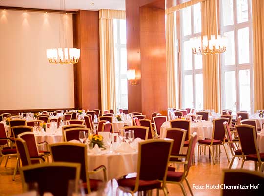 Saal mit gelben Vorhängen, dunkelroten Stühle und schönen Lampen beim Krimidinner Chemnitz 