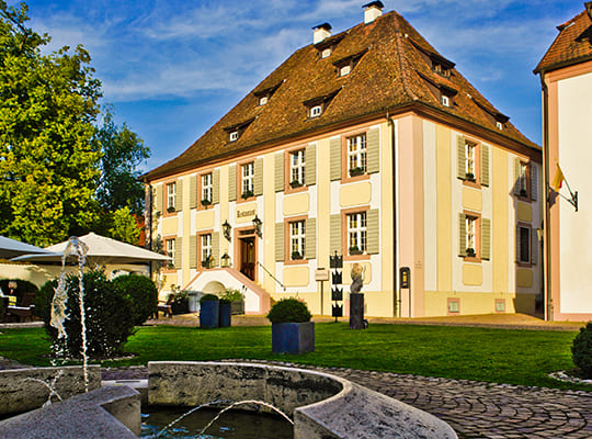 Blick vom schönen Springbrunnen auf das sonnenbestrahlte Hotel Gebäude