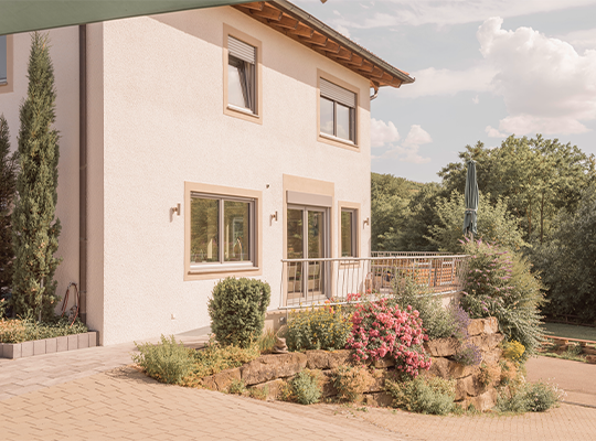 Haus von außen mit kleinem Garten und Pflanzen davor