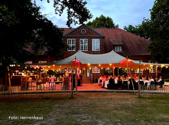 Festgesellschaft im Garten des Herrenhauses unter Pavilion mit Lichteffekten beim Krimidinner Lübeck