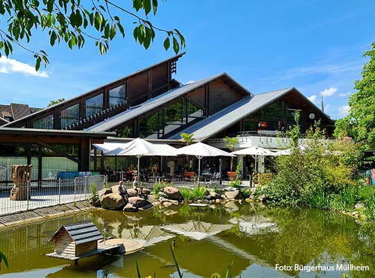 Teich vor dem Bürgerhaus Müllheim, Außenbereich mit Sonnenschirmen und Sitzplätzen beim Krimidinner