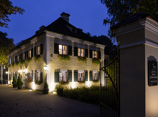 Blick vom Eingangstor auf den Innenhof des Restaurants in der abendlichen Beleuchtung