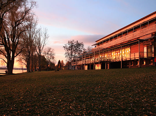 Von der Sonne angestrahltes Restaurantgebäude am Bodensee in der Abenddämmerung.