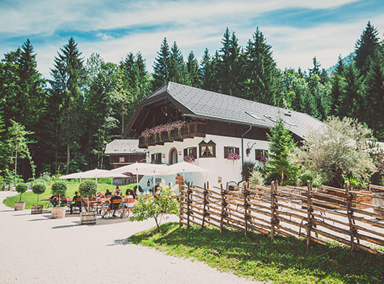 Schöner Blick von der Straße auf das Restaurant mit einem großen Außenbereich und viel Grün.