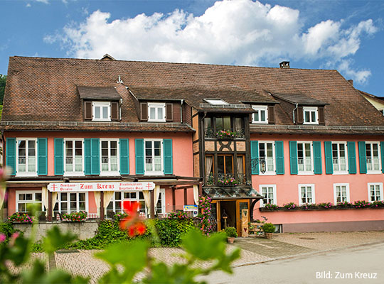 Frontale Außenansicht von: Zum Kreuz, mit roter Fassade und grünen Fensterläden