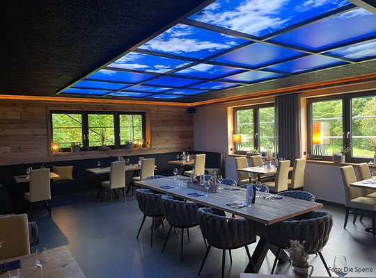 Innenansicht des Restaurants mit Wolkendecke und Sicht aus Fenster herraus